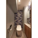 花柄のクロスが印象的なトイレ。
手洗いカウンターや壁に照明を設置して快適な空間になりました。　