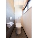 トイレはTOTOの定番節水便器、「ピュアレスト」。上品でやわらかみのあるフォルムが人気です。石柄の壁紙と床材と組み合わせ、大人の落ち着いた雰囲気に。