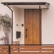 パイン材の木目柄が際立つ玄関ドアは、外壁の色、昭和レトロなタイルとも調和しています。ドアを取り替え、断熱性能が向上。以前の家の良さを残しつつ、現代風に生まれ変わりました。