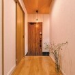 玄関ドアは、やや赤味のあるミディアムトーンに仕上げたパイン柄と節、鋸目の荒々しさを再現したタイプを選択。
異なるデザインのドアが、廊下から見える景色を新鮮に映します。