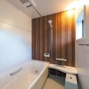 LIXILのシステムバス・アライズは、ブラウン（オンダガタライト）のアクセントパネル、ベージュの床で暖かみを演出。お掃除ラクな床は冬場もひんやりせず、浴槽はお湯が冷めにくい保温構造です。