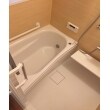清潔感あふれる白色のバスルームを包み込むのは、木彫デザインの壁パネル。ホテルの浴室のような、安らぎの空間になりました。
