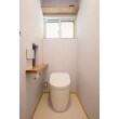 床やクロスはシンプルなデザインのものを使用し、清潔感のあるトイレに。ナチュラルな色合いの棚板やペーパーホルダーがオシャレです。