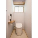 床やクロスはシンプルなデザインのものを使用し、清潔感のあるトイレに。ナチュラルな色合いの棚板やペーパーホルダーがオシャレです。