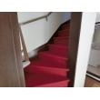 既存の階段の上から赤いカーペットを張り付け、上品かつ滑り止めの効果もあります。手摺も取り付けました。