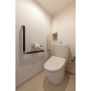 シンプルな白色で統一したトイレ空間。ちょっとした収納やL型手すりがうれしい。