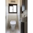 １階のトイレはタンクレスのトイレを設置。壁はお掃除がしやすいように、腰高の高さまでパネルを設置。壁面に収納・手洗い器を設置いたしました。