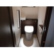 LIXILリフォレ トイレはキャビネットや手すりの木部の色を合わせ、落ち着いたシックな空間に。お掃除道具やトイレットペーパーも収納できるキャビネットで便器のまわりがすっきりとお掃除も簡単です！