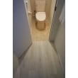木目調の廊下からテラコッタタイル調のトイレへ。フロアタイルで素敵に雰囲気を変えて。