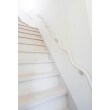 ホールに合わせて白を基調にした階段は、明るく2階まで導いてくれる空間に。波型手すりがアクセントに。