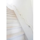 ホールに合わせて白を基調にした階段は、明るく2階まで導いてくれる空間に。波型手すりがアクセントに。