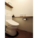 トイレ背面には棚を、サイドにはカウンターを造作。
カウンター部分のコンセントで携帯電話の充電ができるように。また、壁にはLDKと同じアクセントクロスを貼り、落ち着いた雰囲気のトイレ空間に。