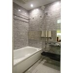 石積み調の壁でイメージを合わせた浴室