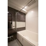 チャコールグレー調のタイルが落ち着きを演出する浴室
