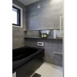 石目と黒い浴槽のスタイリッシュな浴室
