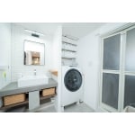 幅広カウンターの洗面台と洗濯機を壁で分けて造作収納を追加