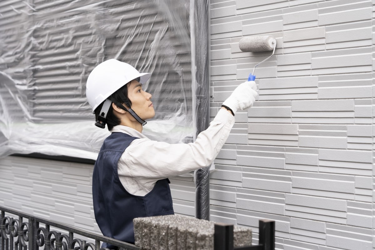戸建住宅の外壁塗装をする職人の男性
