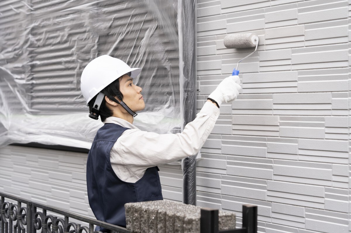 戸建て住宅の外壁塗装をする職人
