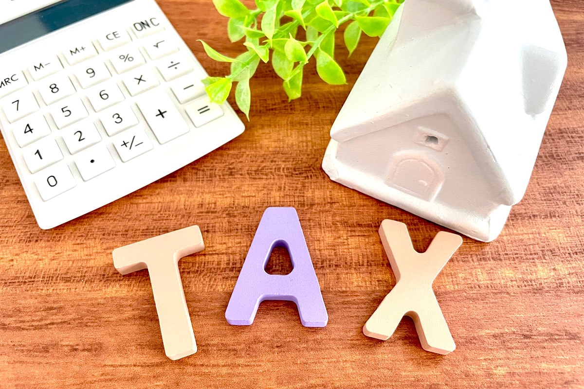 家の模型と電卓、TAXの文字