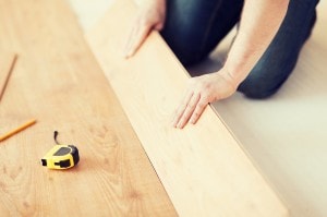 close up of male hands intalling wood flooring