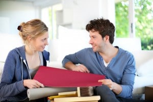 Young couple choosing wallpaper color for new apartment