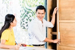 Asian couple buying cabinet in furniture store