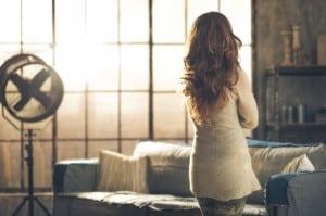 Brunette looking out industrial chic loft window