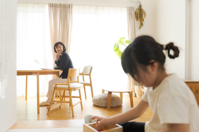 小上がりで遊ぶ子どもを見守る母親