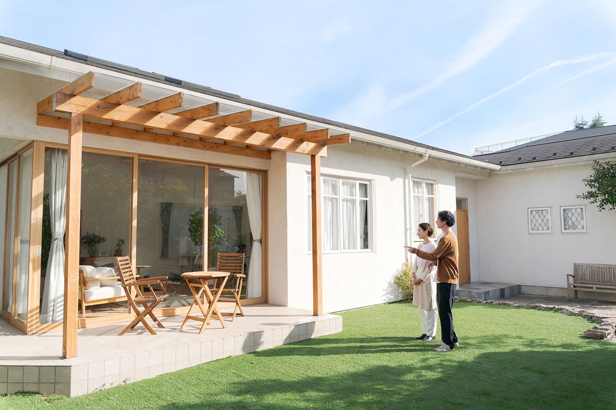 綺麗な家の庭に立つ夫婦