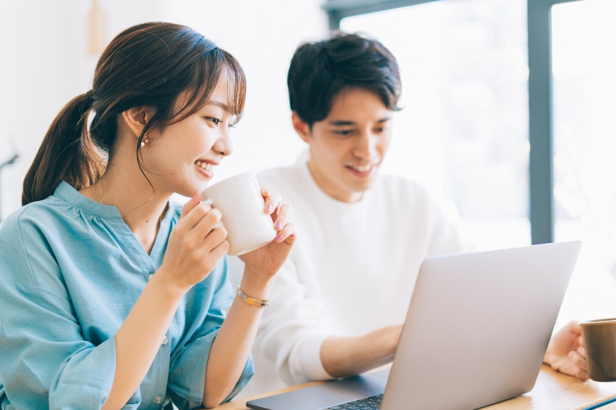 パソコンを見て相談する夫婦のイメージ