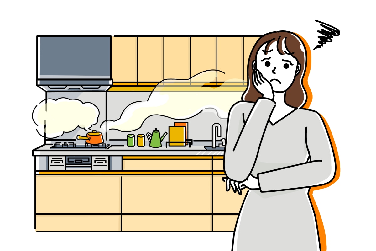 レンジフードの吸い込みが悪く、キッチンに匂いが篭り困っている女性の様子